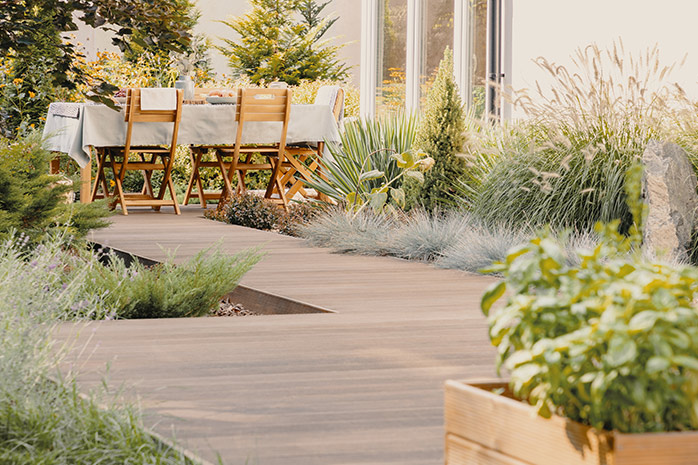 Große Terrasse mit Gartenmöbel, eingefasst mit Pflanzen