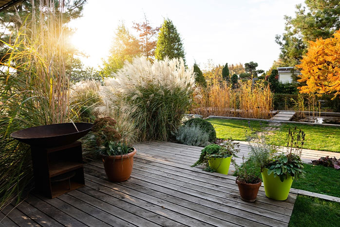 Terrasse mit Pflanzen umranden wirkt dekorativ und ist eine natürliche Lösung für Windfang oder Sichtschutz