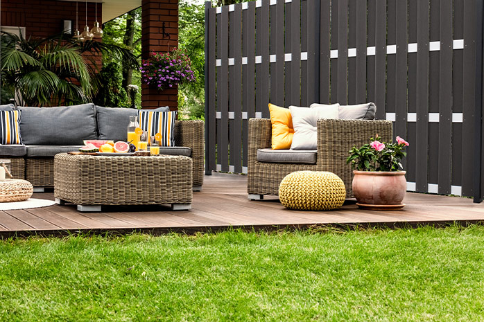 WPC-Terrasse im Garten mit Sitzmöglichkeiten, Deko und Kübelpflanze
