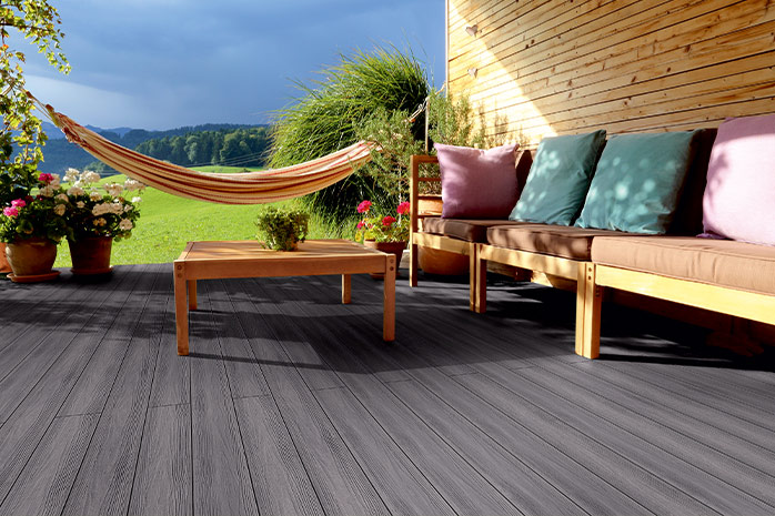 Graue WPC-Terrasse mit Holzmöbel, Hängematte und Weitsicht