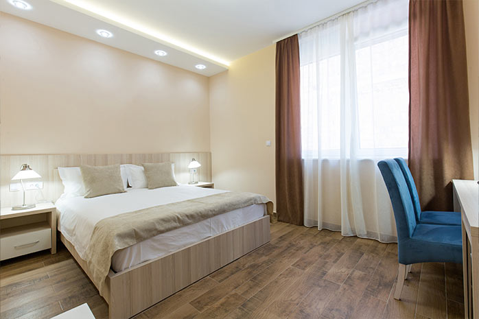 "Interieur eines Hotelzimmers mit Doppelbett und eleganten Möbeln"